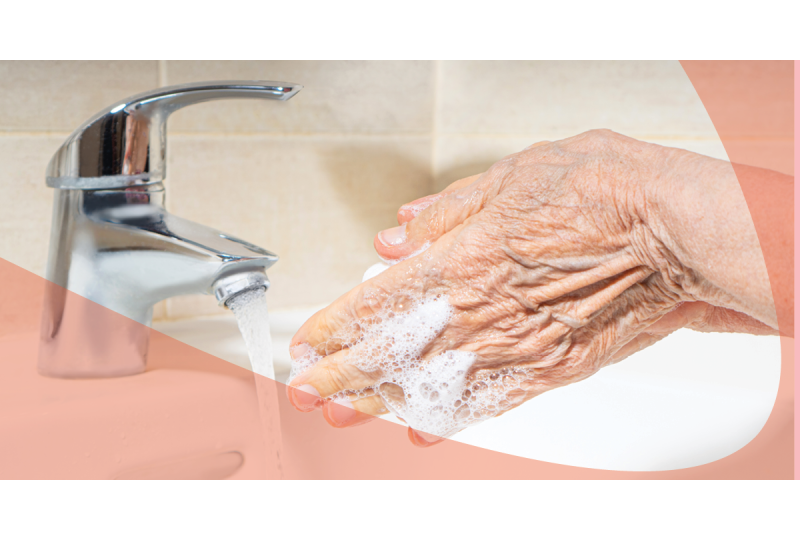 senior washing hand with foaming soap at sink