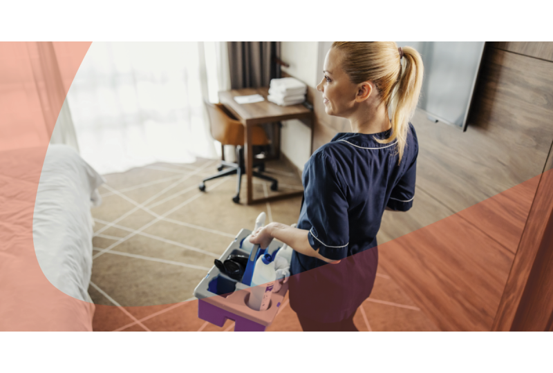 housekeeper holding cleaning supply caddy in hotel room