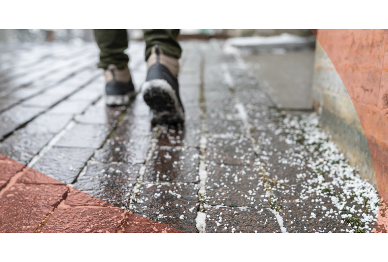 person walking in winter boots over pavement with rock salt