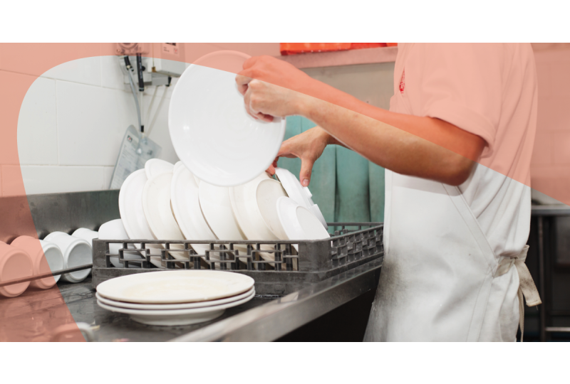 man unloading commercial dishwasher